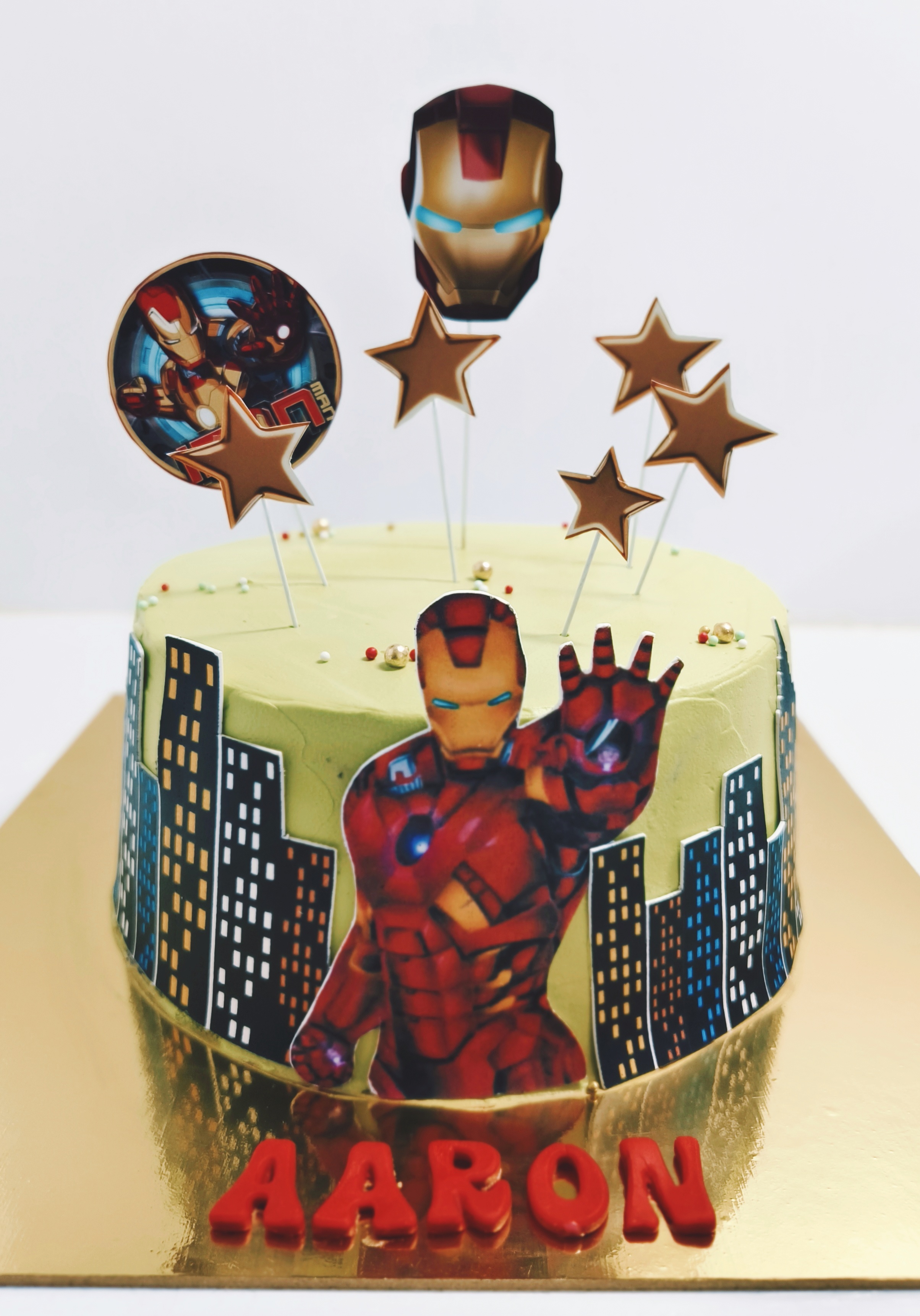 Superhero-themed birthday cake with city-skyline detail and star toppers