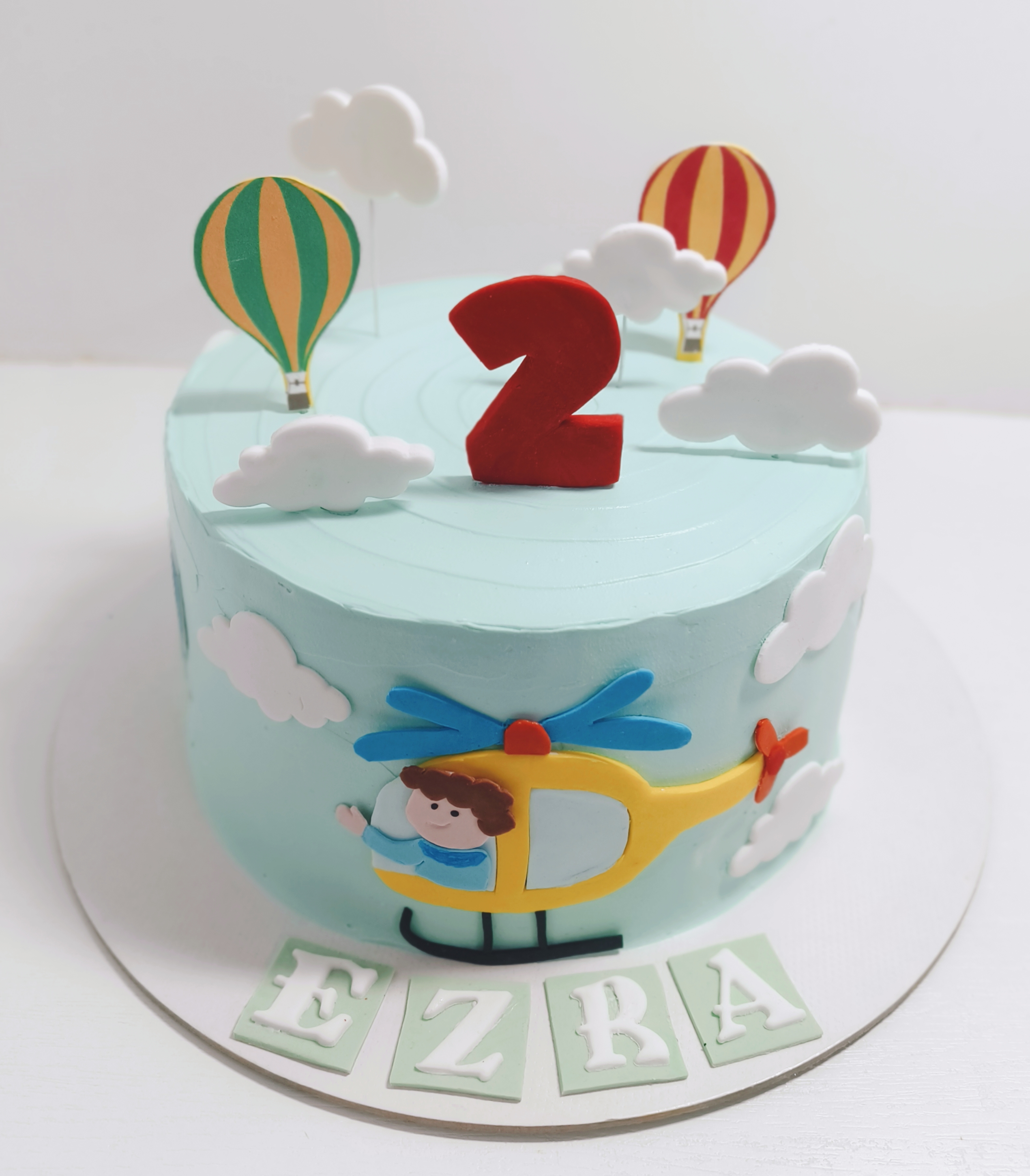 Sky-themed birthday cake with hot-air balloons, clouds, and a helicopter design